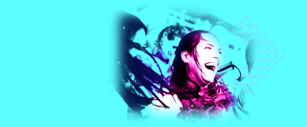 A woman is laughing in front of a blue background.