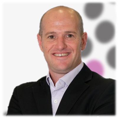 A bald man in a suit smiles for the camera.
