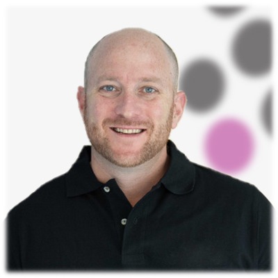A bald man in a black shirt is smiling.