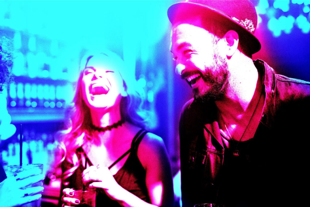 A group of people laughing in a bar.